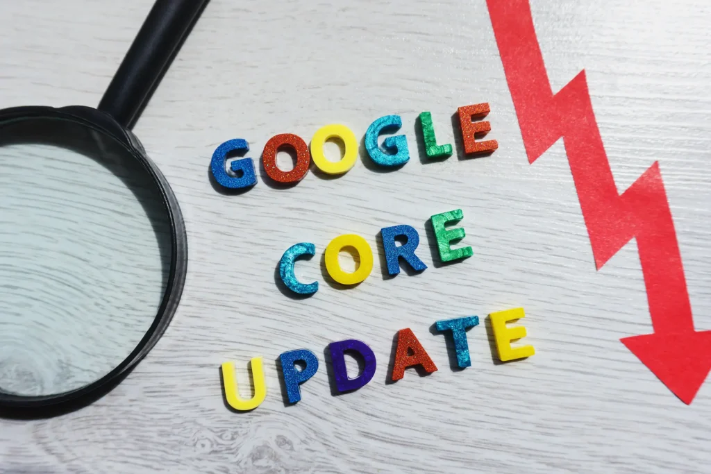Rappresentazione grafica del core update di Google con lettere colorate, una freccia rossa e una lente d'ingrandimento.